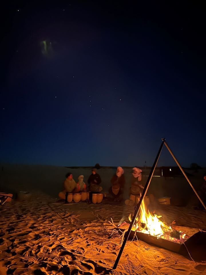 hoguera en el desierto de noche con gente alrededor en marruecos